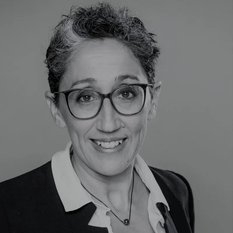 Portrait de Farida Fekih en noir et blanc, portant des lunettes